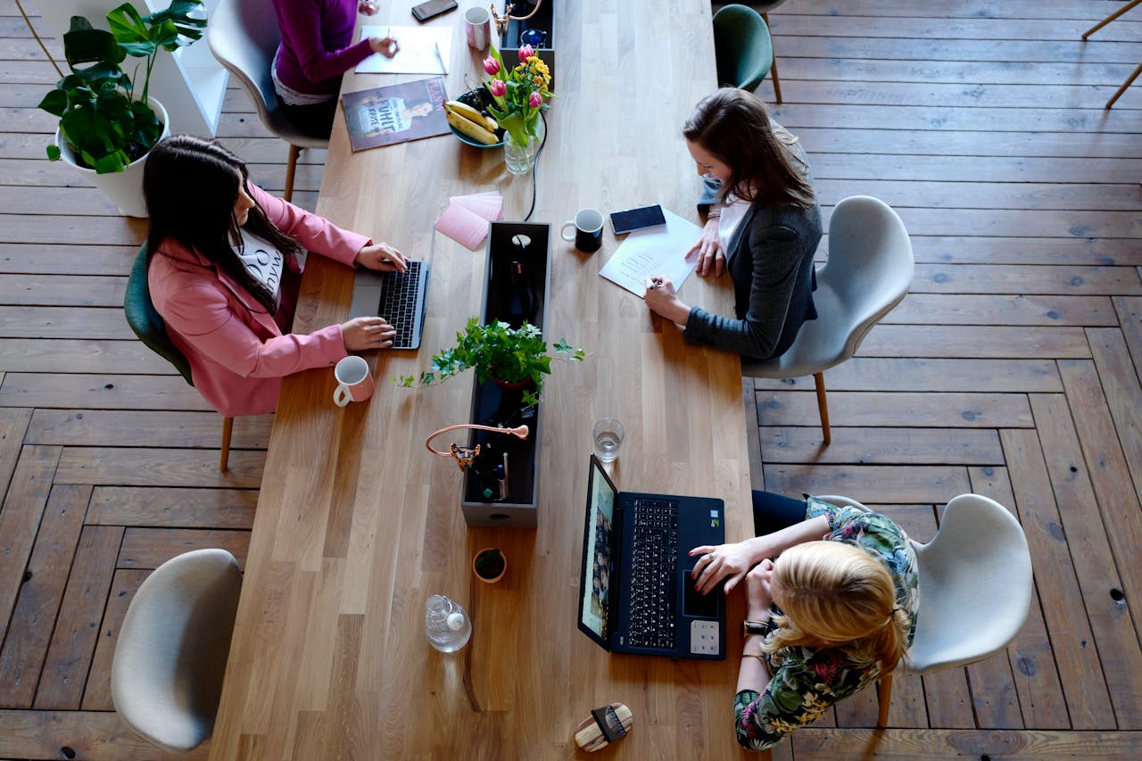 our-services-2 Overhead view of diverse women professionals working in a modern office setting, fostering collaboration and teamwork.